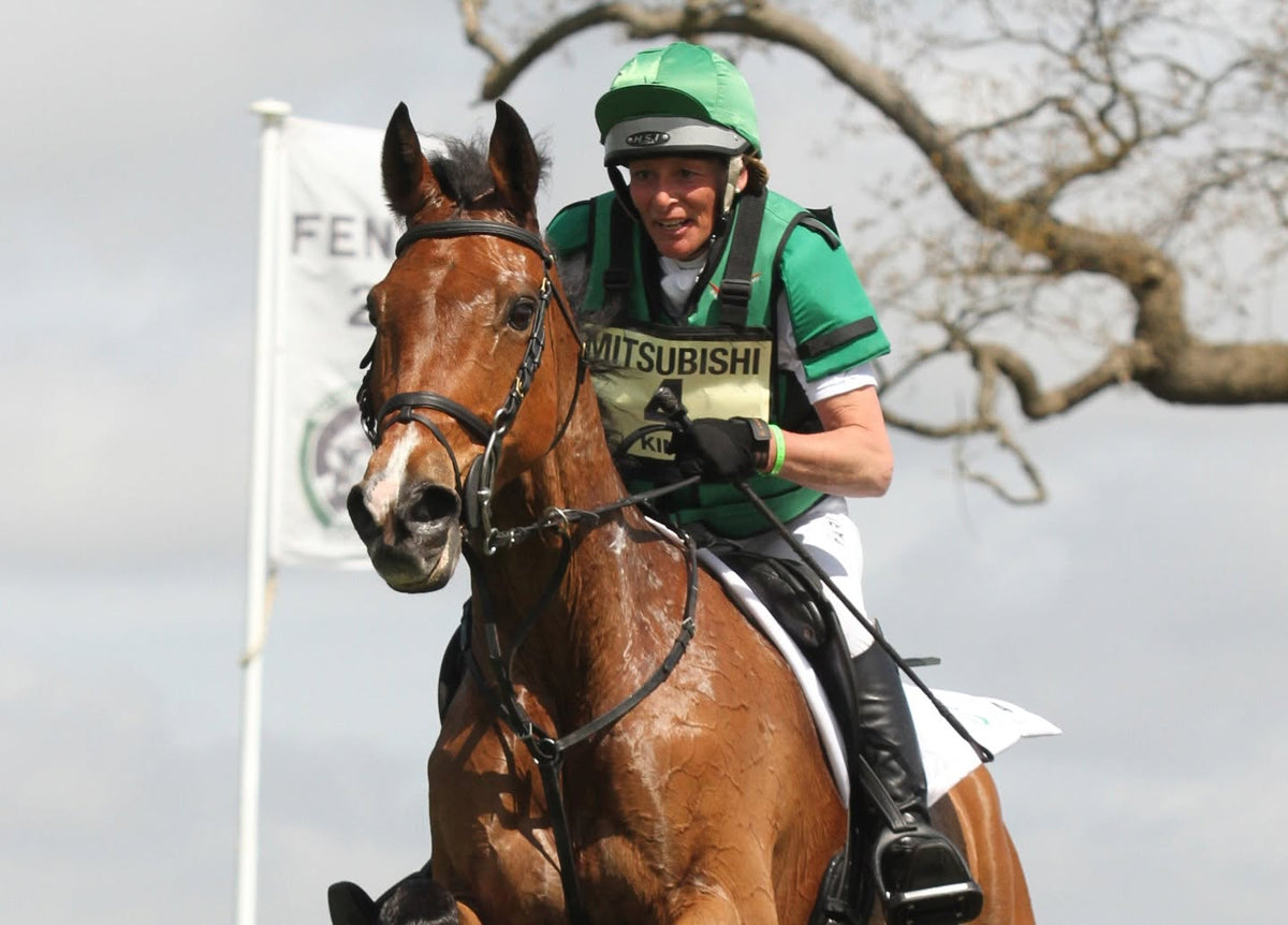 Mary King in a green Point Two air vest riding cross country.